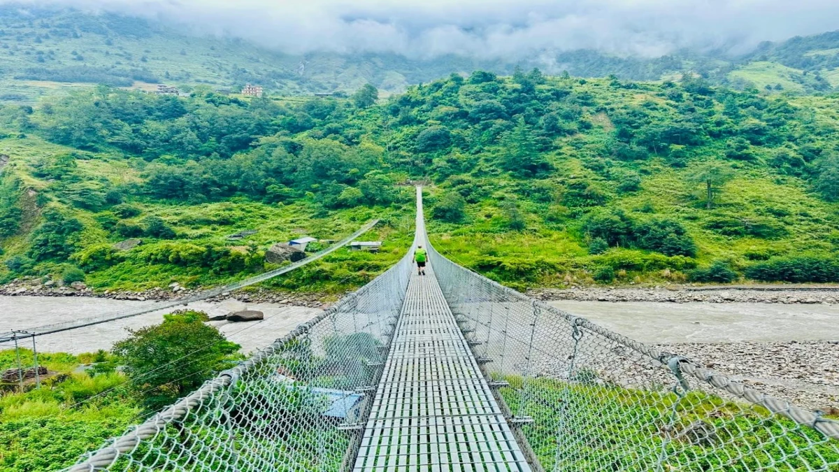 A suspension bridge on the lower Budhi Gandaki approach trail, socked in by monsoon cloud