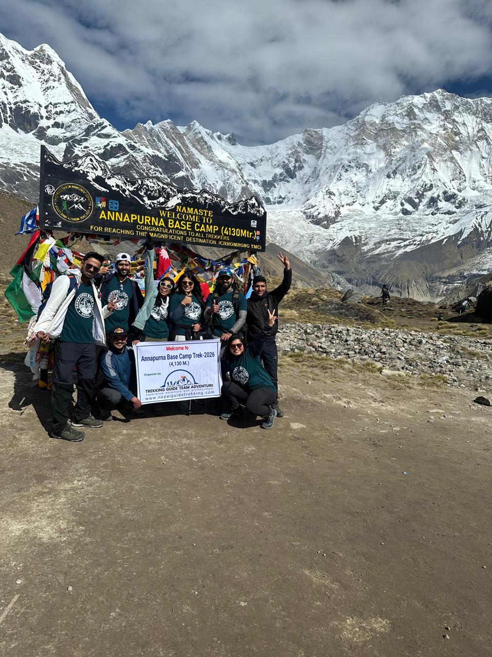 Group of trekkers at Annapurna Base Camp 4130m welcome sign Nepal Trekking Guide Team Adventure