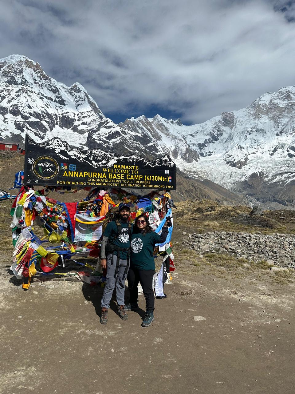 Couple at Annapurna Base Camp 4130m welcome sign Nepal trek