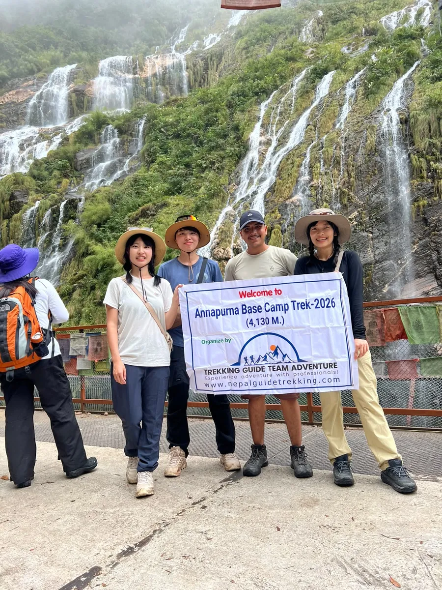 Trekkers beside a waterfall on the Annapurna Base Camp trek